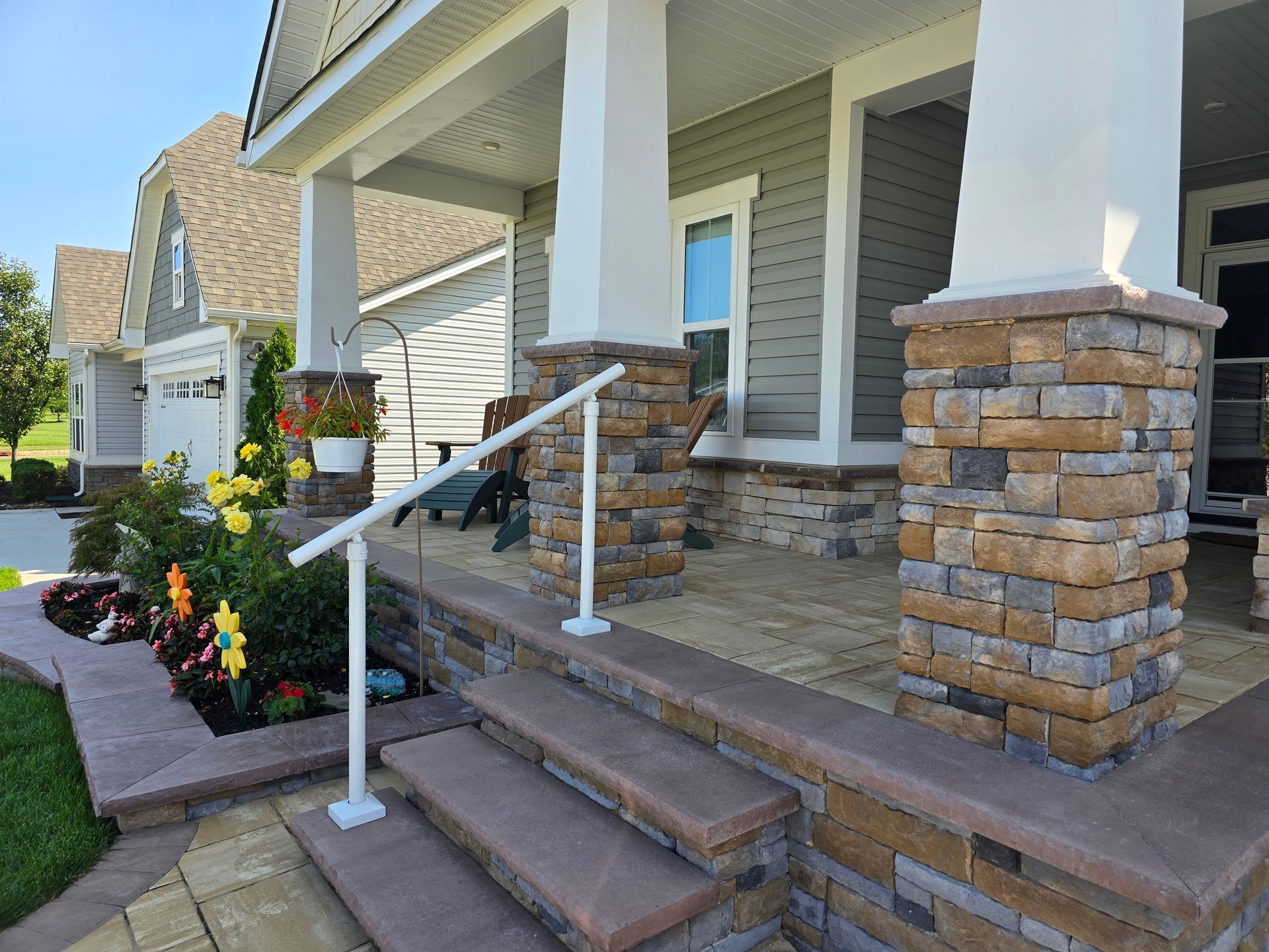 A porch with stairs leading up to it and a white railing.