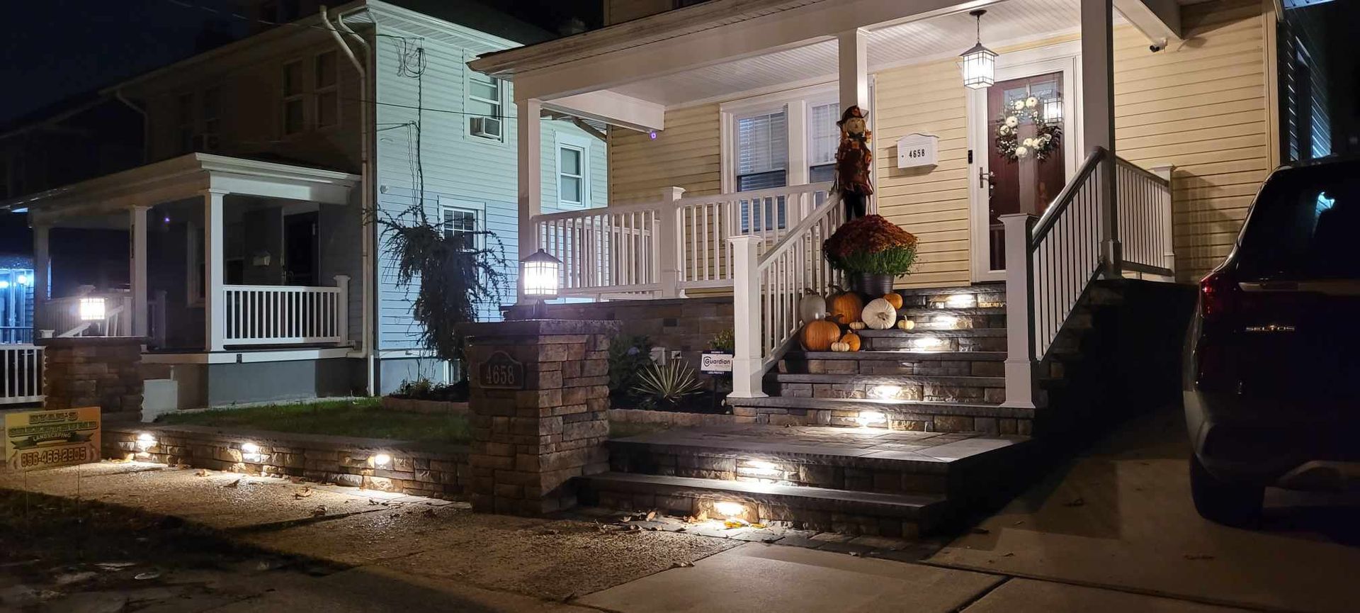 A car is parked in front of a house at night.