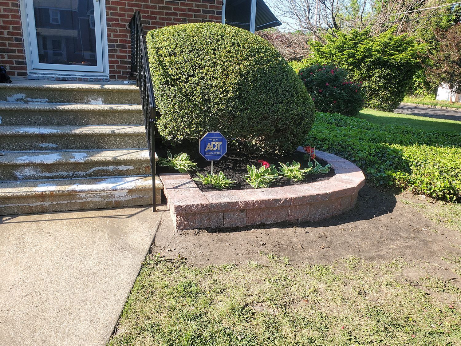 A brick house with a stone planter in front of it.