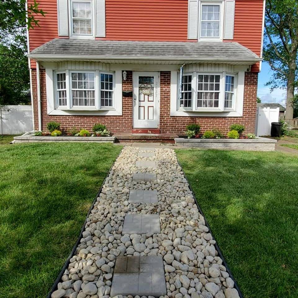 A red brick house with a stone walkway leading to the front door.