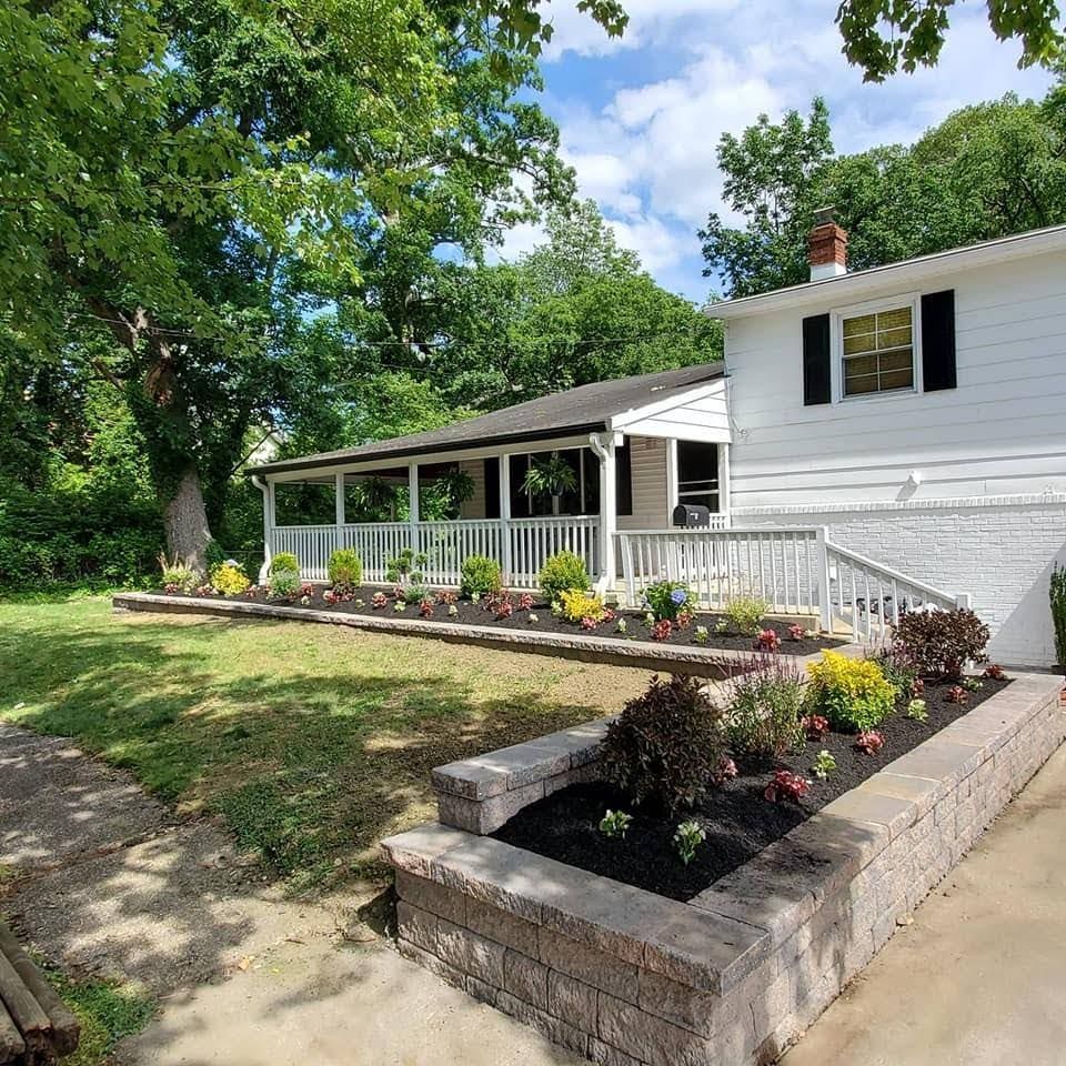 A white house with black shutters and a large porch