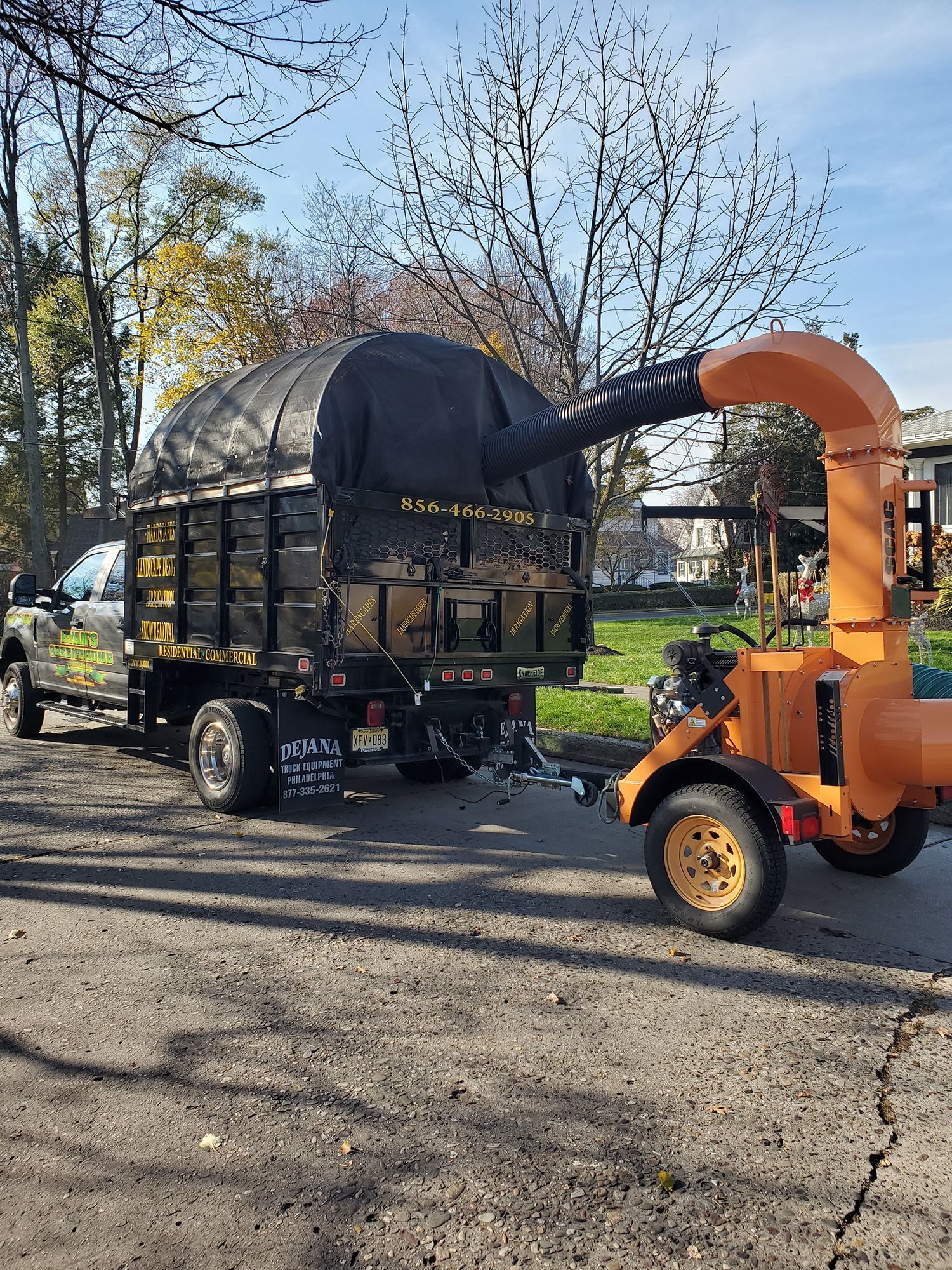 A truck with a trailer attached to it is parked on the side of the road.