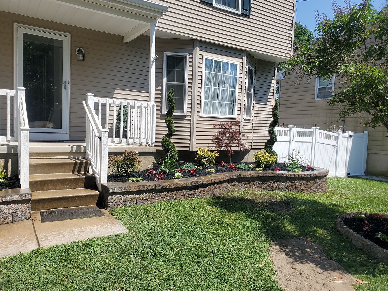 A house with a porch and a white fence