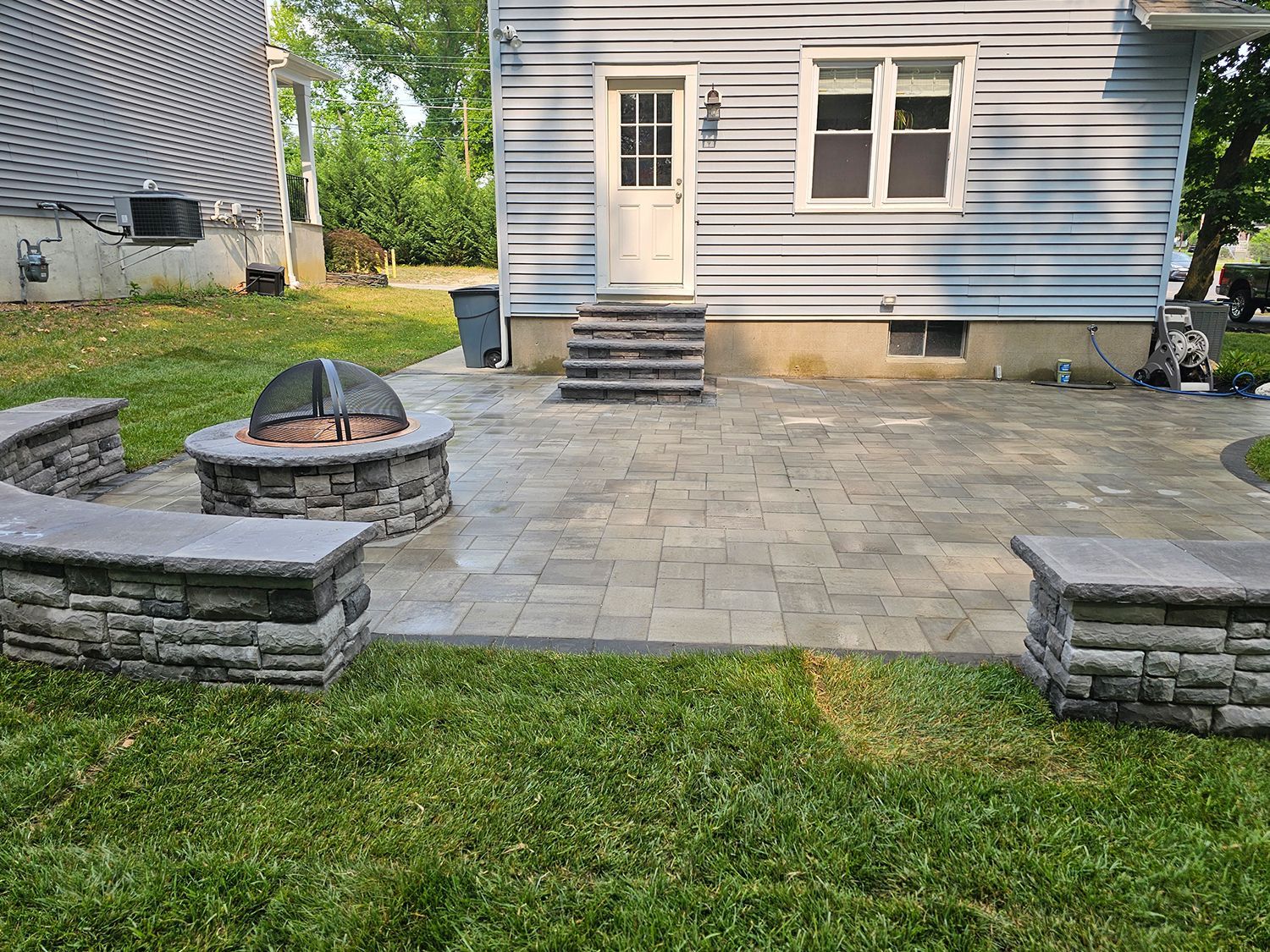 There is a fire pit in the backyard of a house.