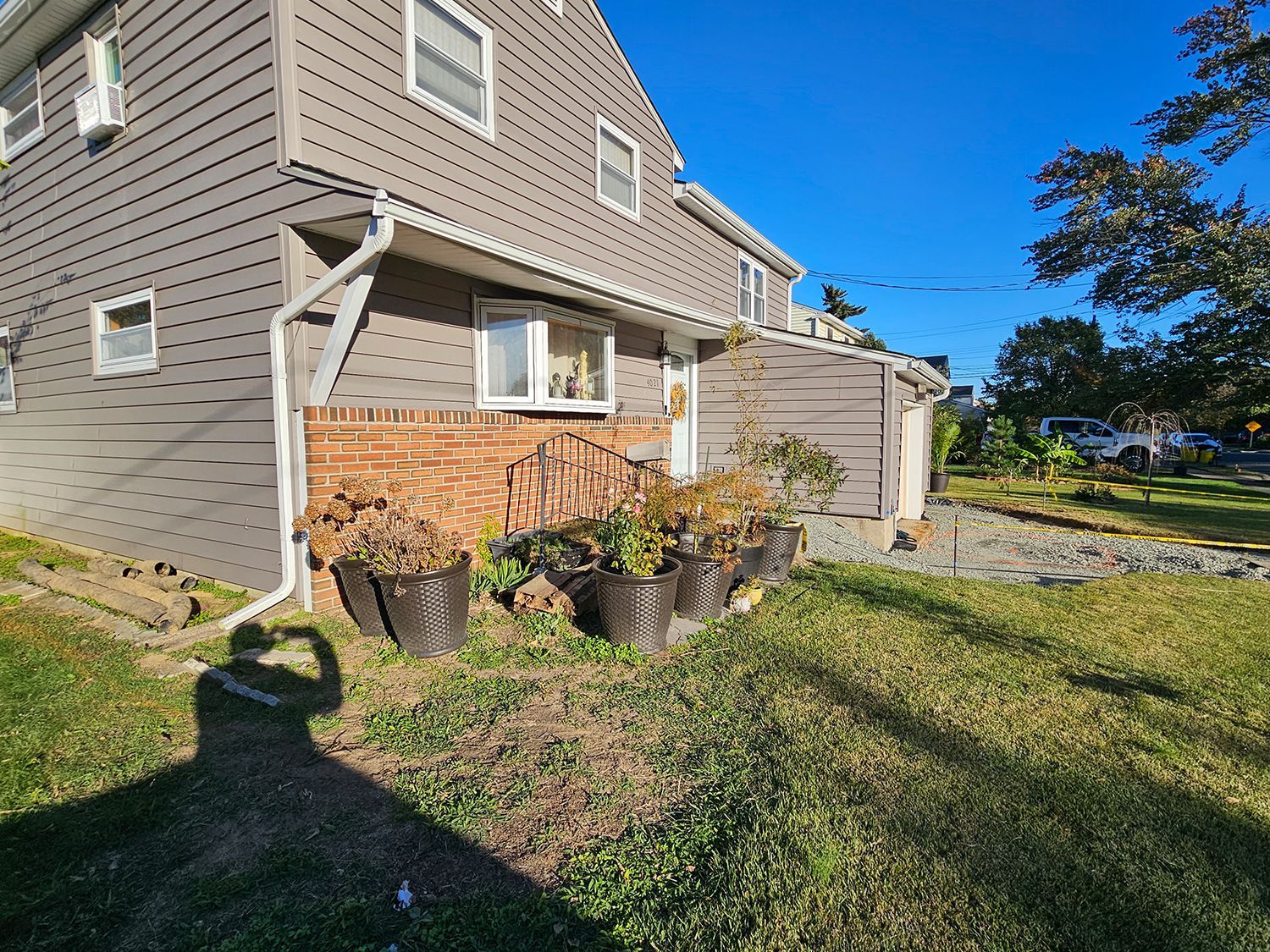 A house with a lot of potted plants in front of it.