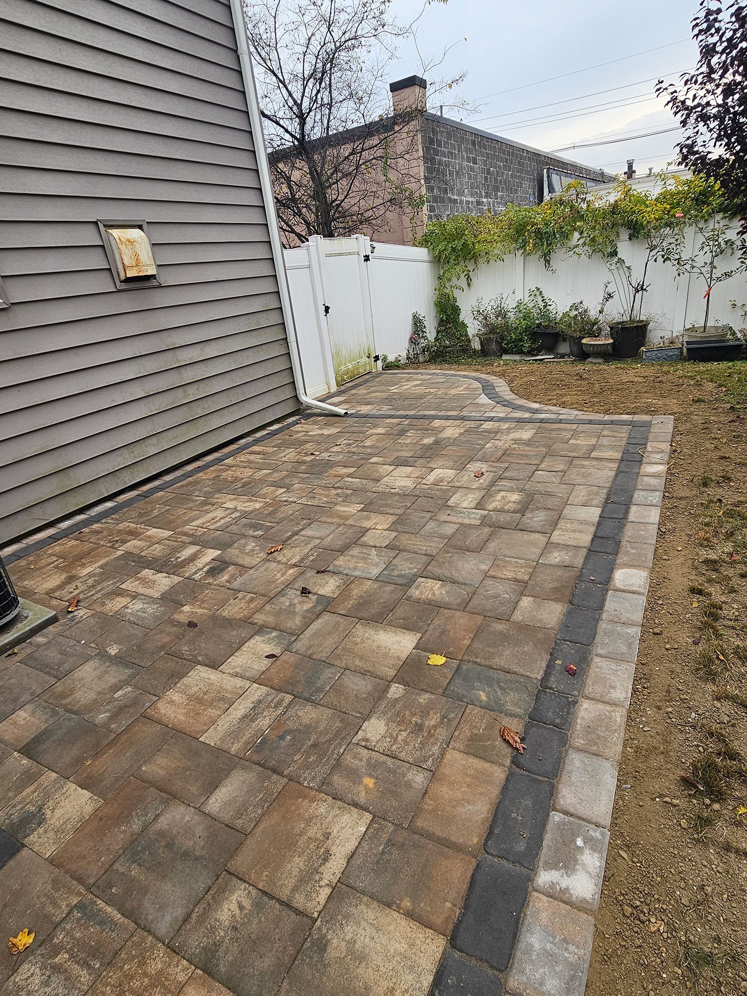 A patio is being built in the backyard of a house.
