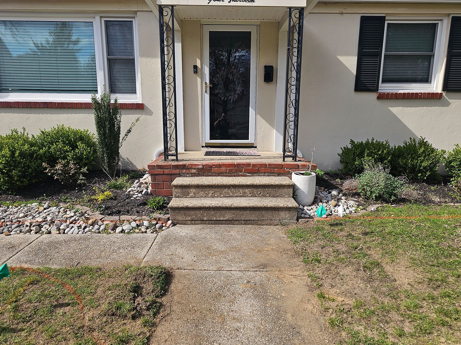 A white house with a brick porch and steps