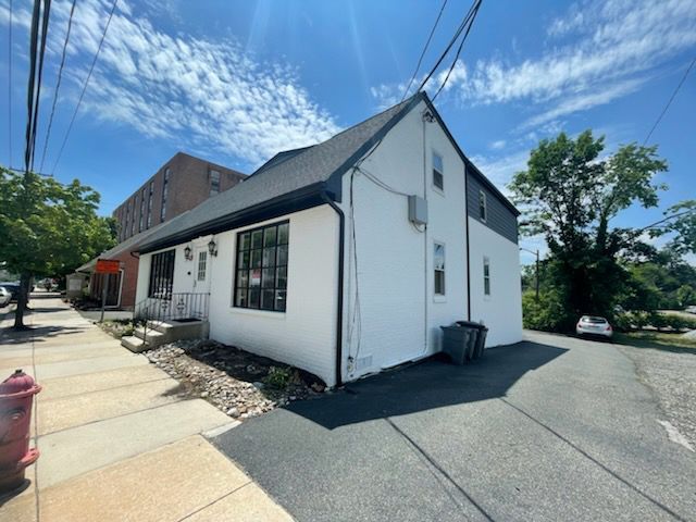 A white house with a fire hydrant in front of it