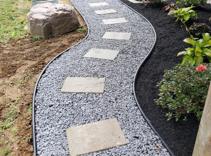 A walkway made of gravel and stepping stones in a garden.