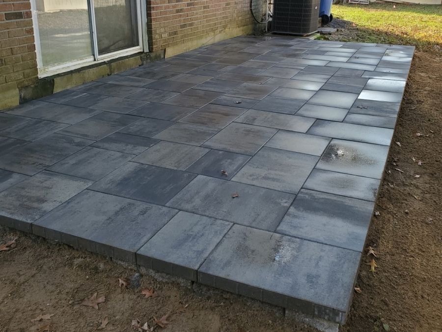 A patio is being built in the backyard of a house.