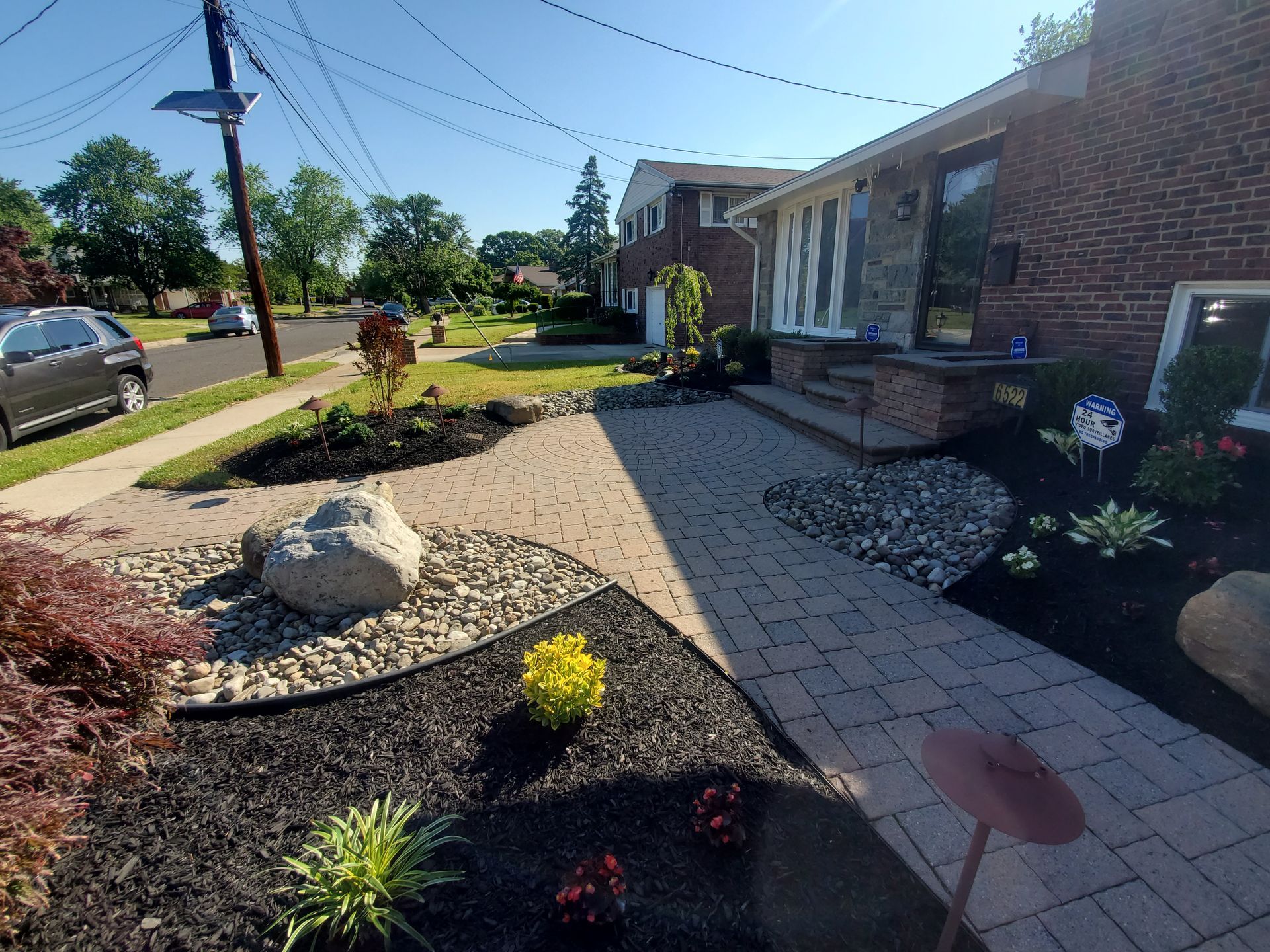 A house with a brick walkway and a garden in front of it
