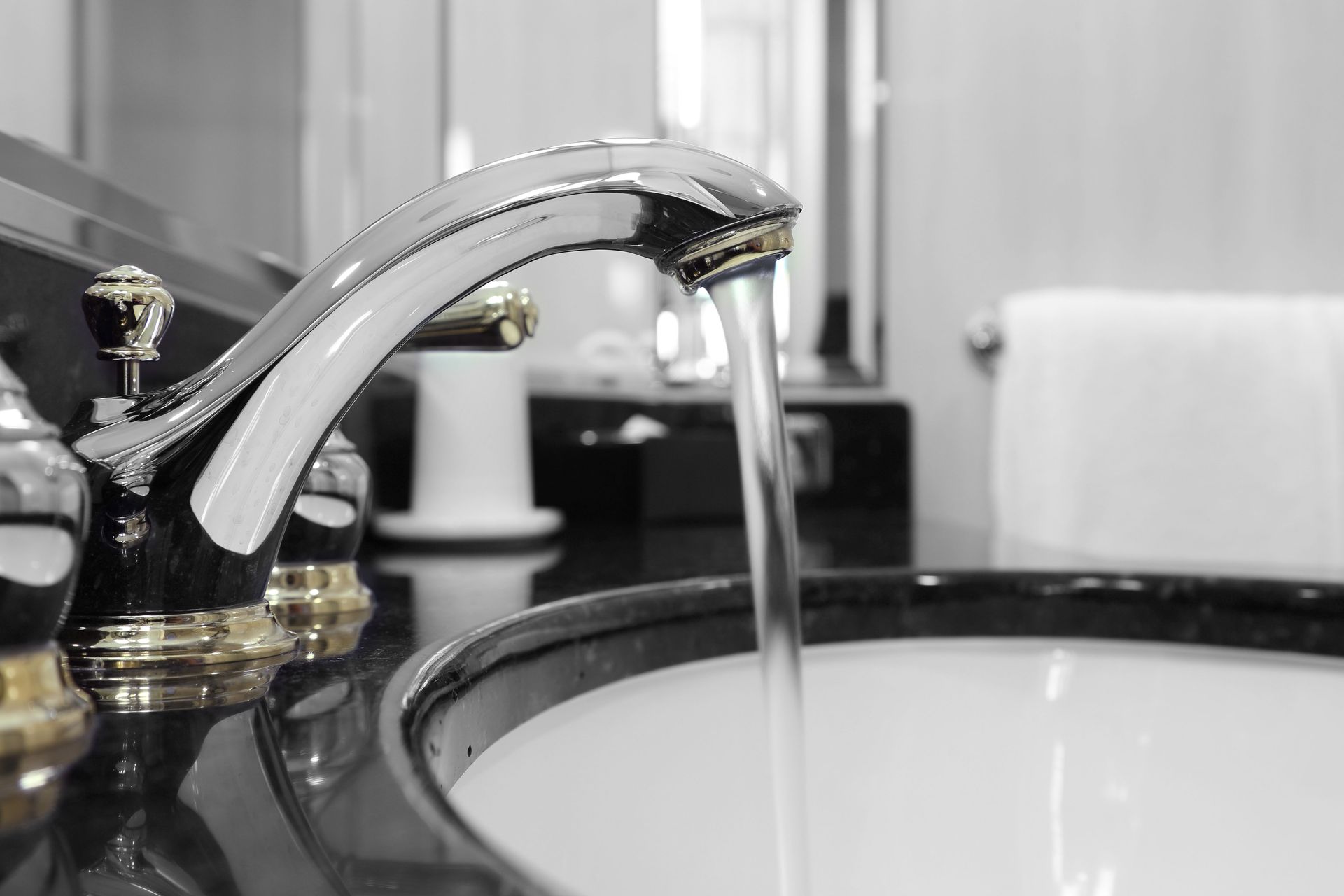 A red wrench and plumbing supplies on a kitchen counter near a double sink.