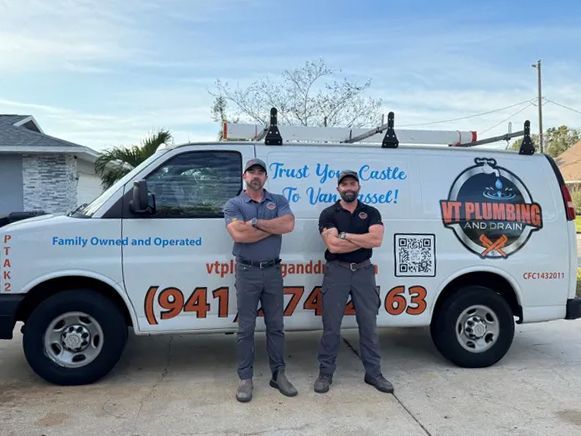 Two plumbers standing in front of a white service van with company logos and phone number.