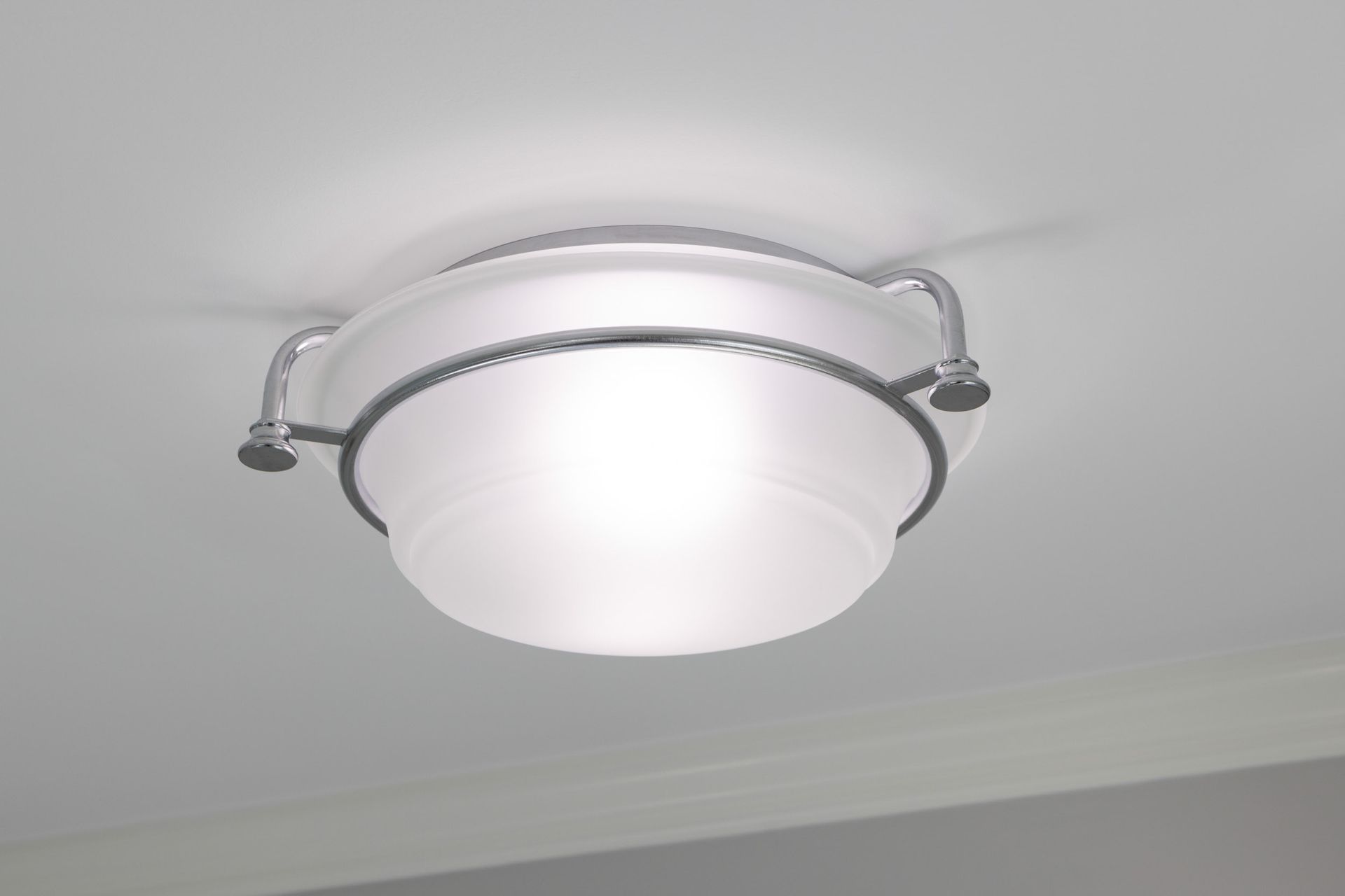 A flush-mount ceiling light with a frosted glass bowl shade secured by a polished chrome frame against a white ceiling.