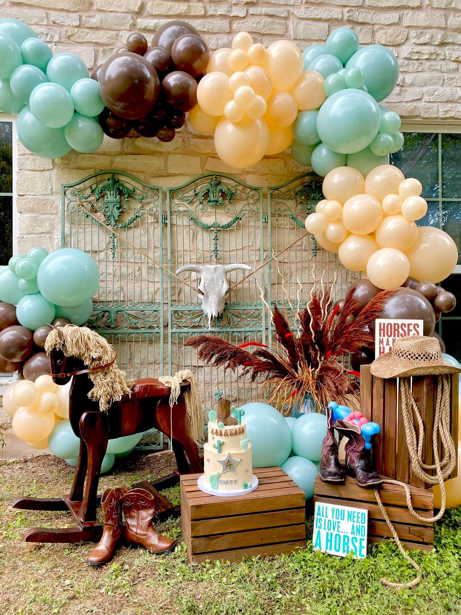 A rocking horse is sitting in front of a wall covered in balloons.