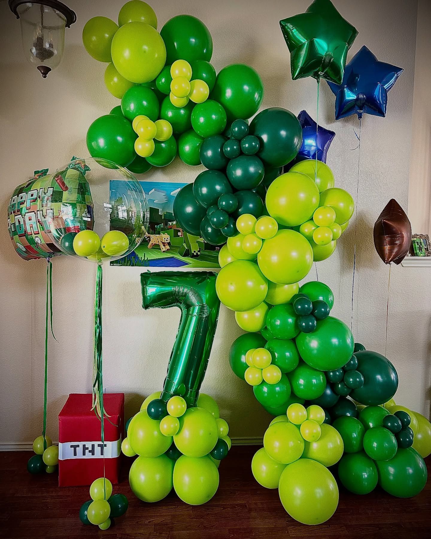 A room filled with green and yellow balloons and a number 7.