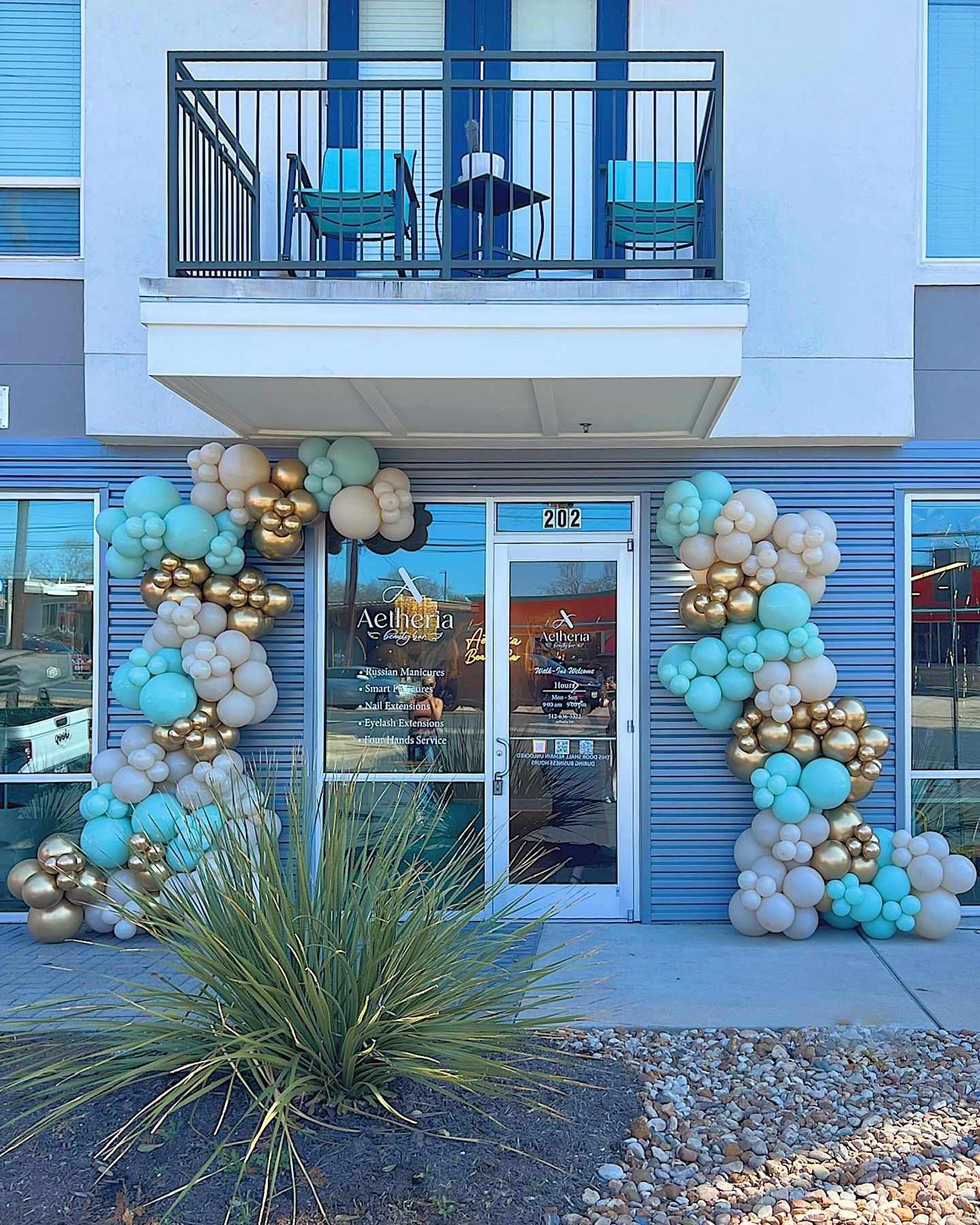 A building with balloons in front of it and a balcony.