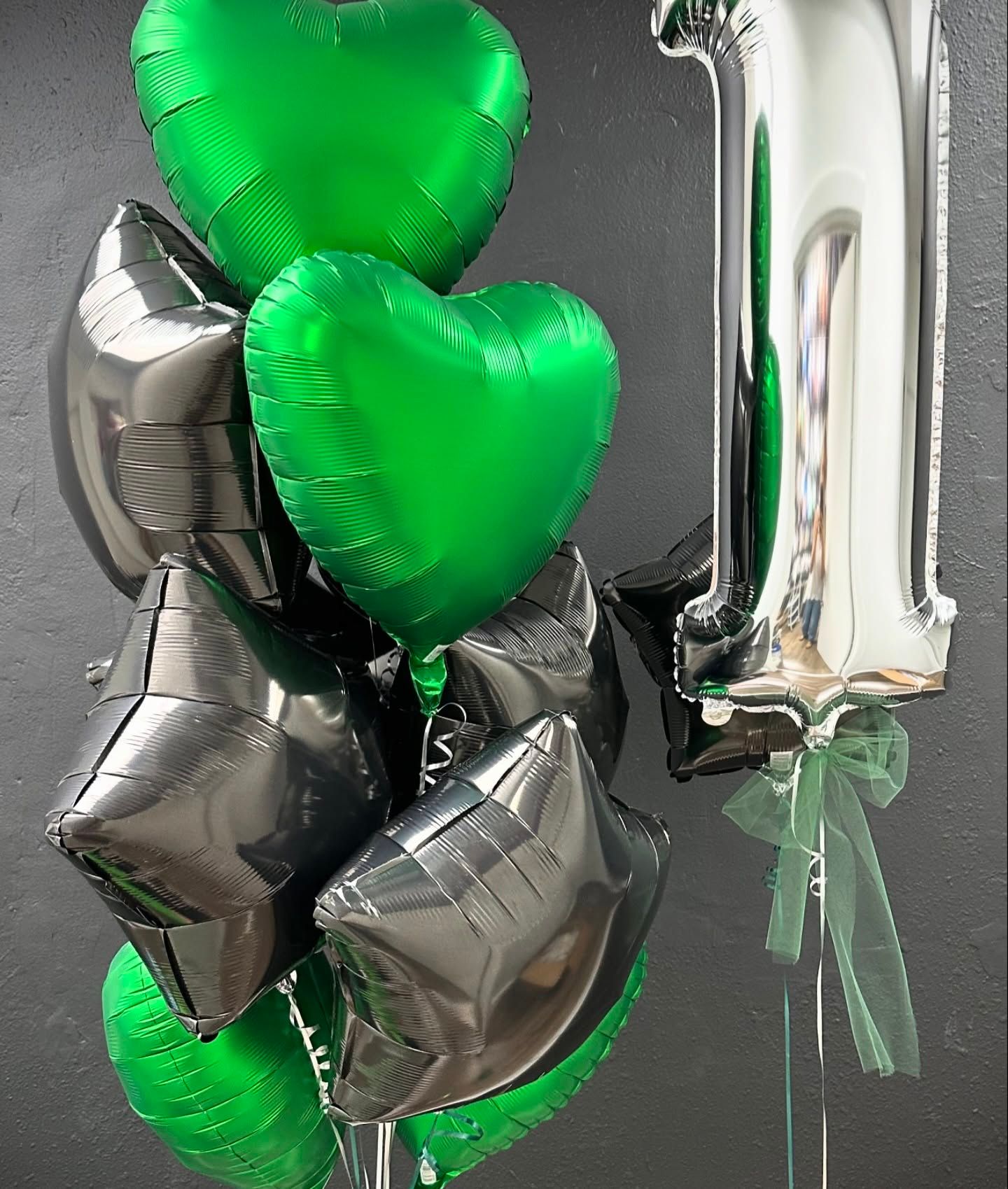 A bunch of green and black balloons with the number 1