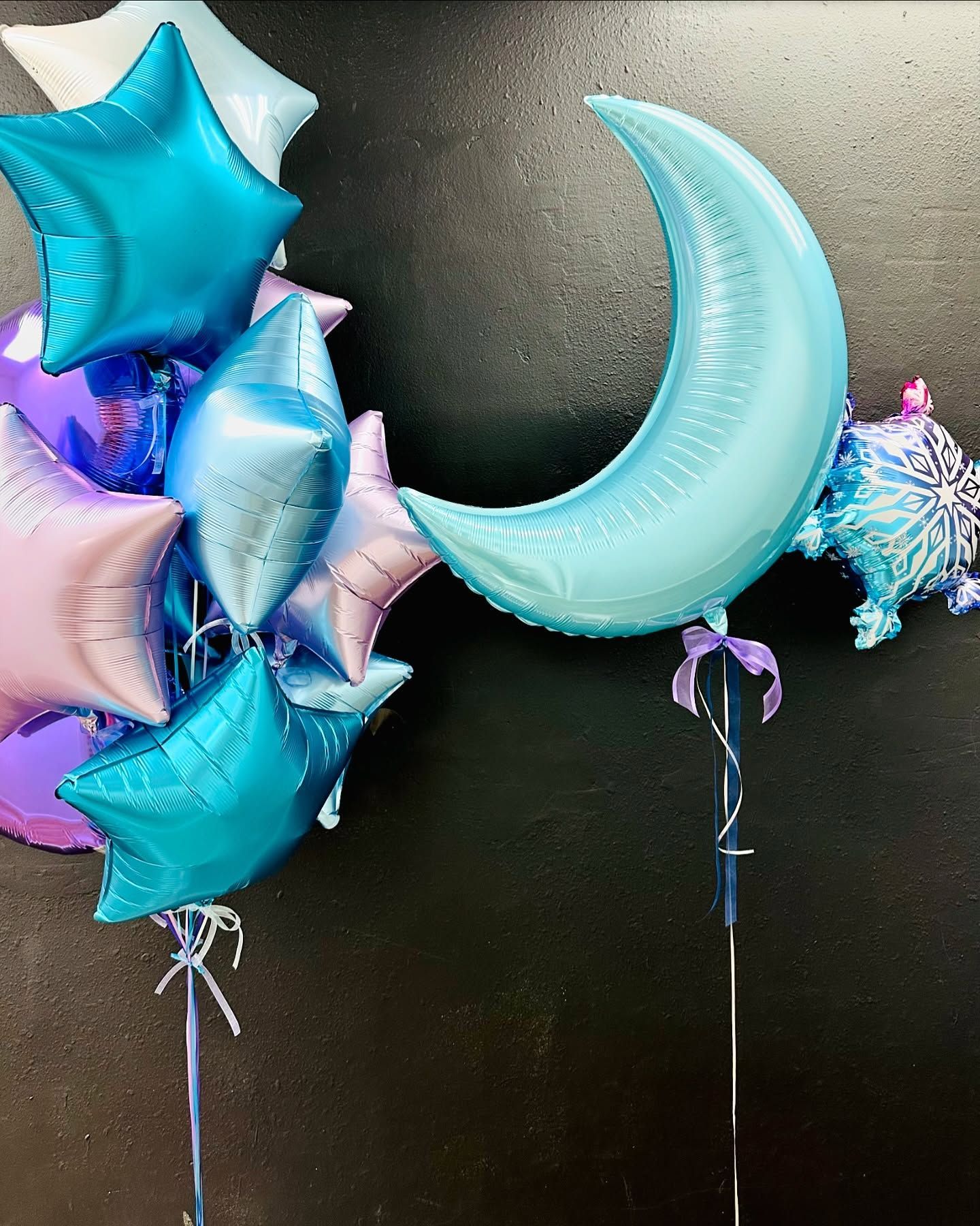 A bunch of balloons including a crescent moon and stars
