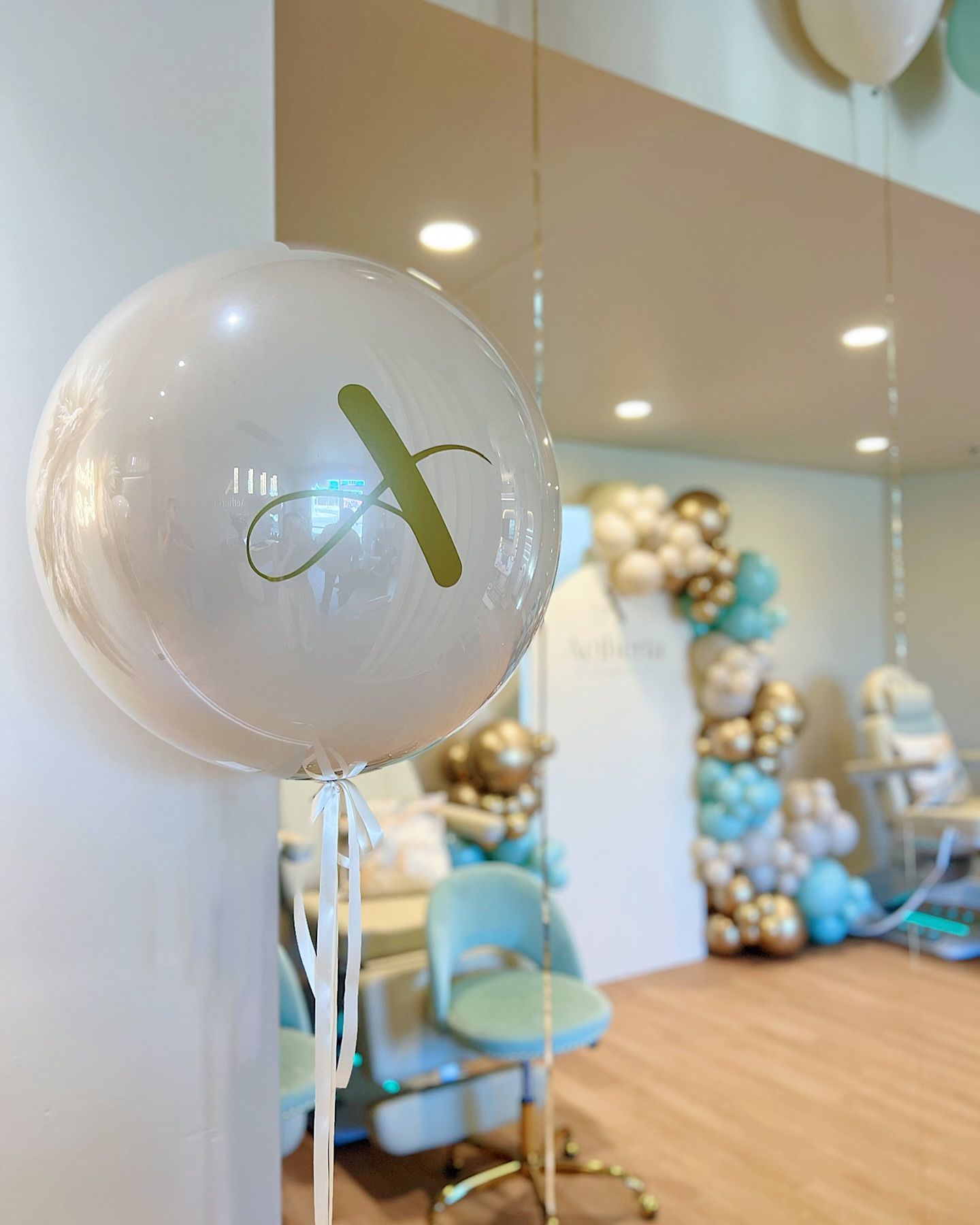 A white balloon with the letter b on it is sitting in a room.