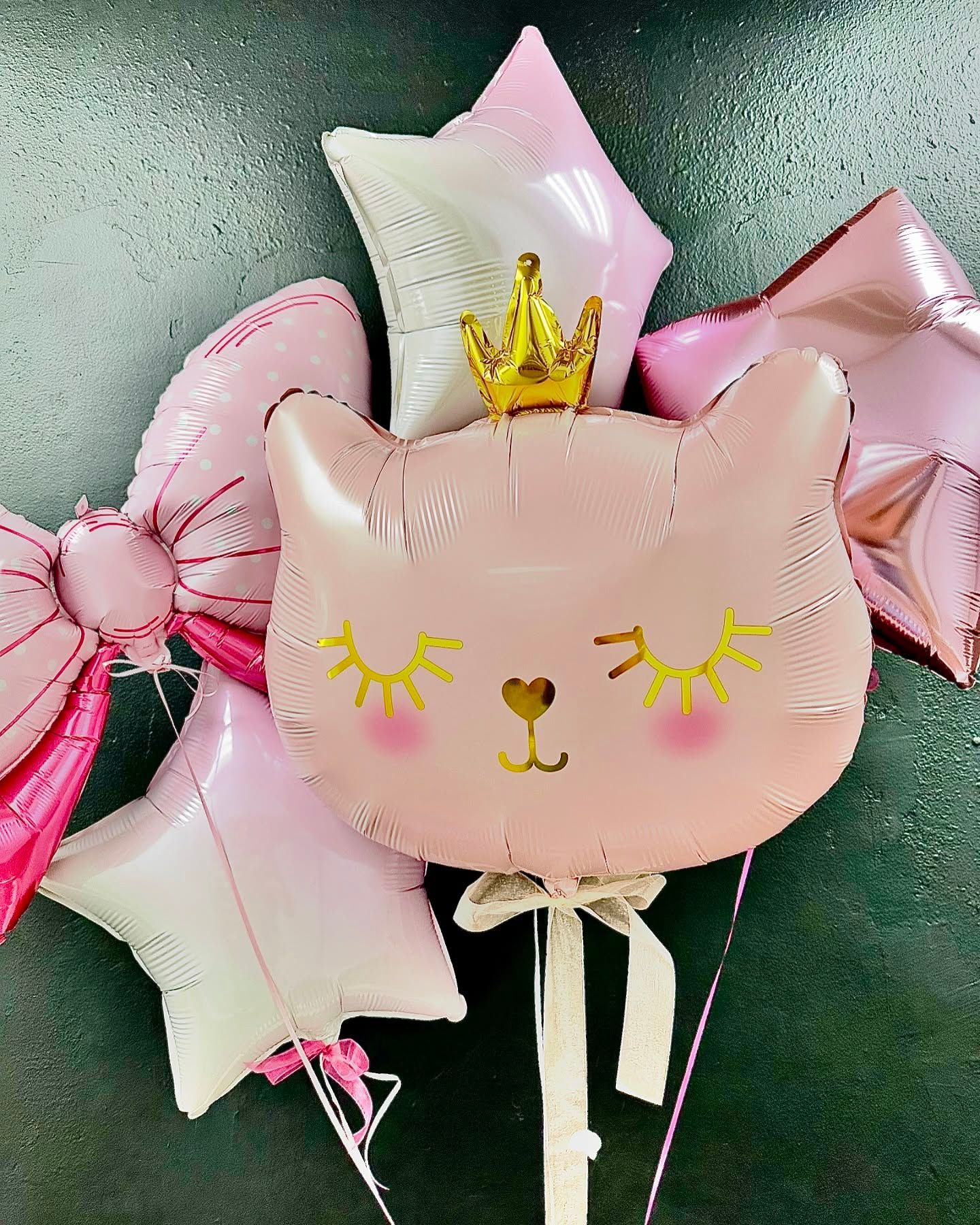 A bunch of pink balloons in the shape of a cat with a crown on it