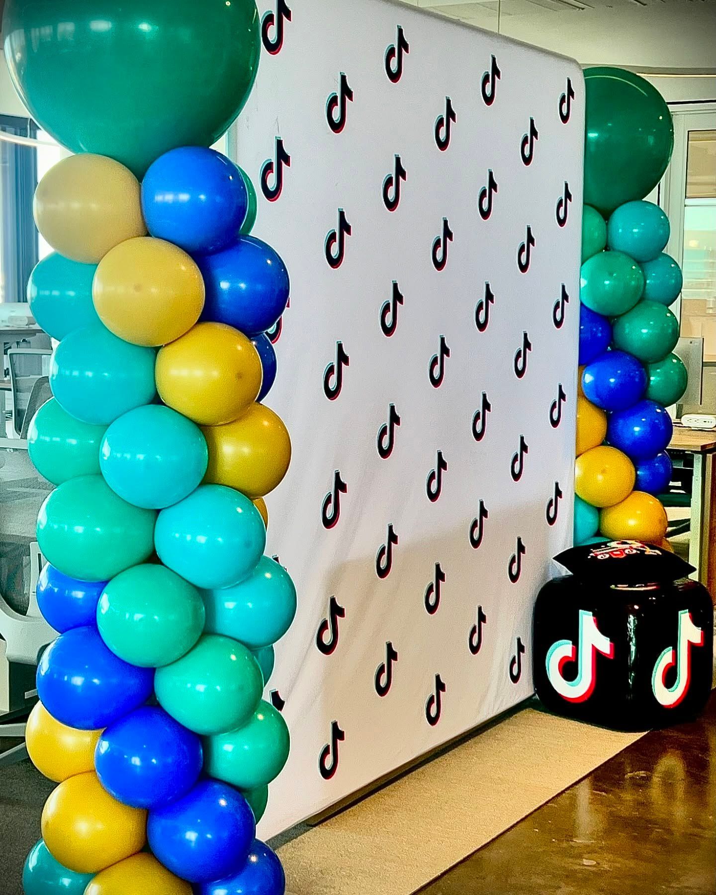 A bunch of balloons are stacked on top of each other on a wall.