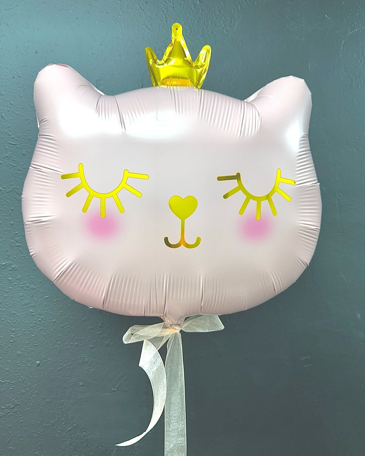 A pink cat balloon with a gold crown on top