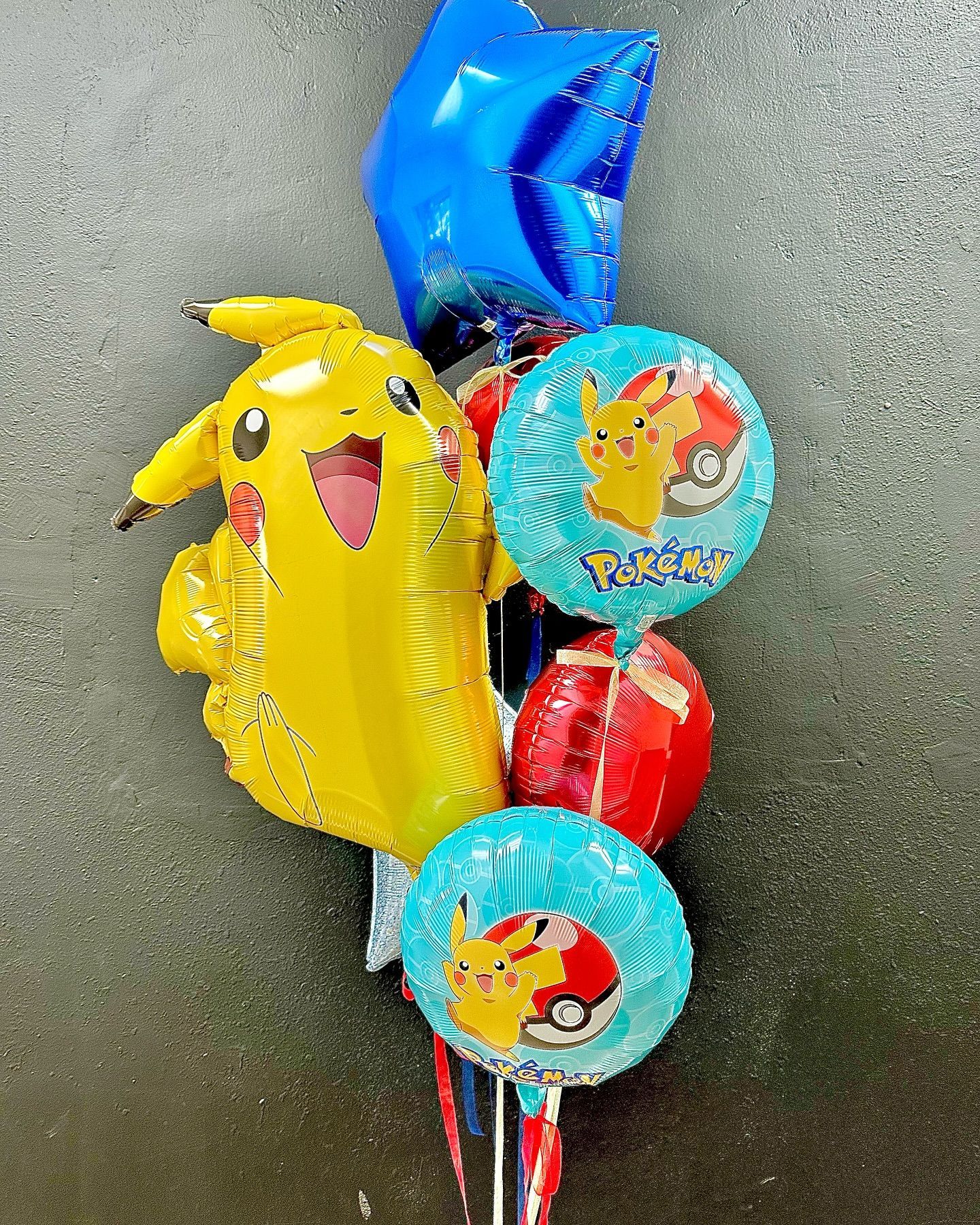 A bunch of balloons with pikachu on them are sitting on a table.