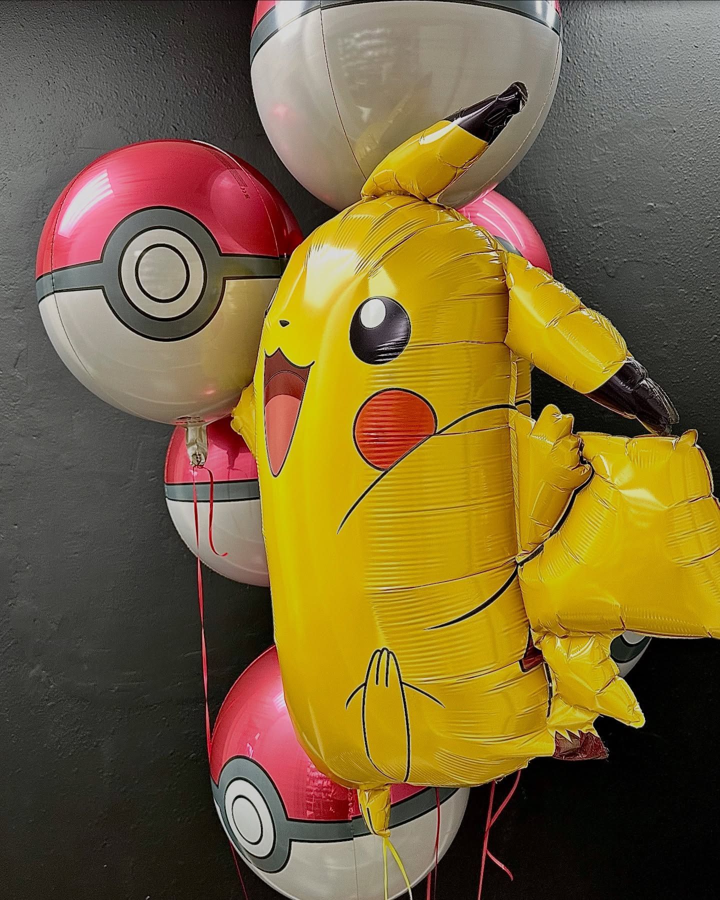 A bunch of balloons with pikachu and pokeballs on them