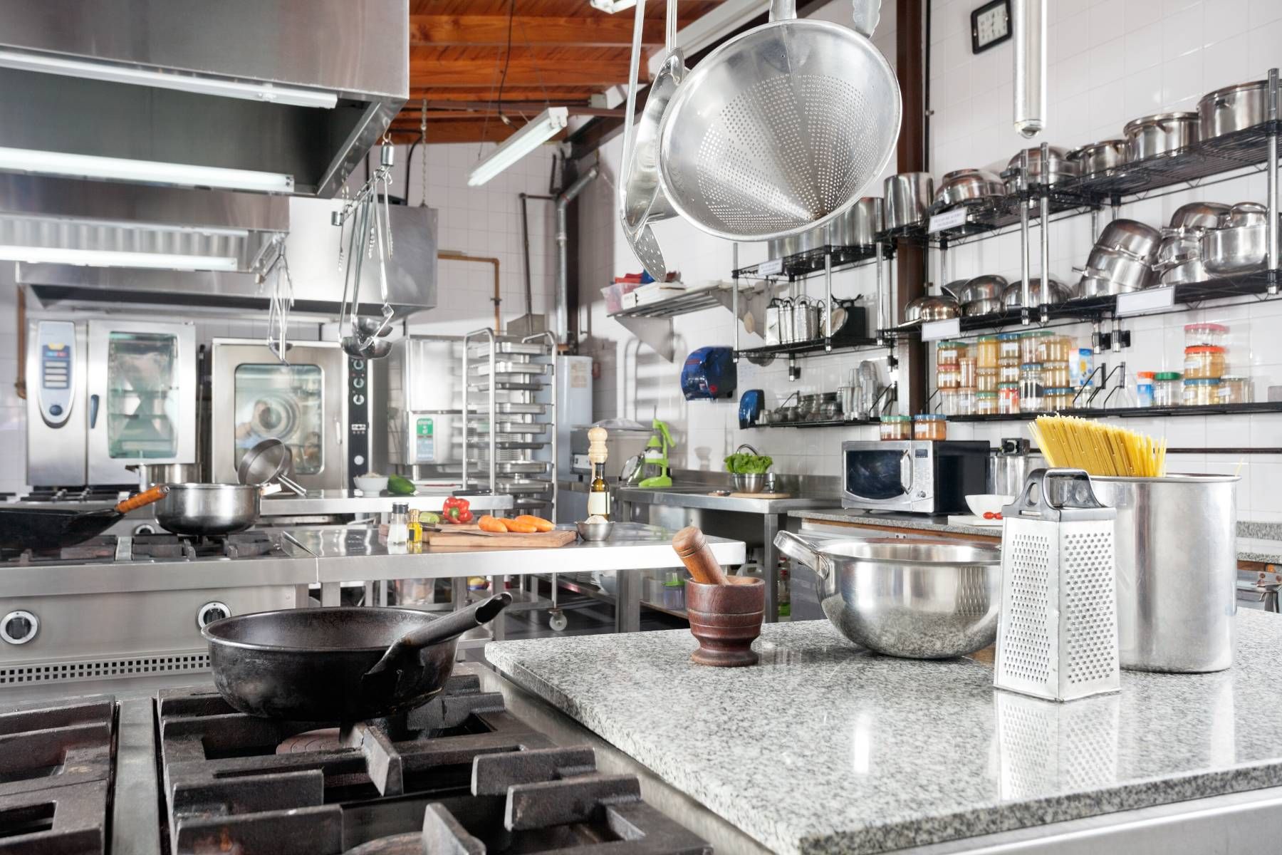 A kitchen with a lot of pots and pans on the stove.