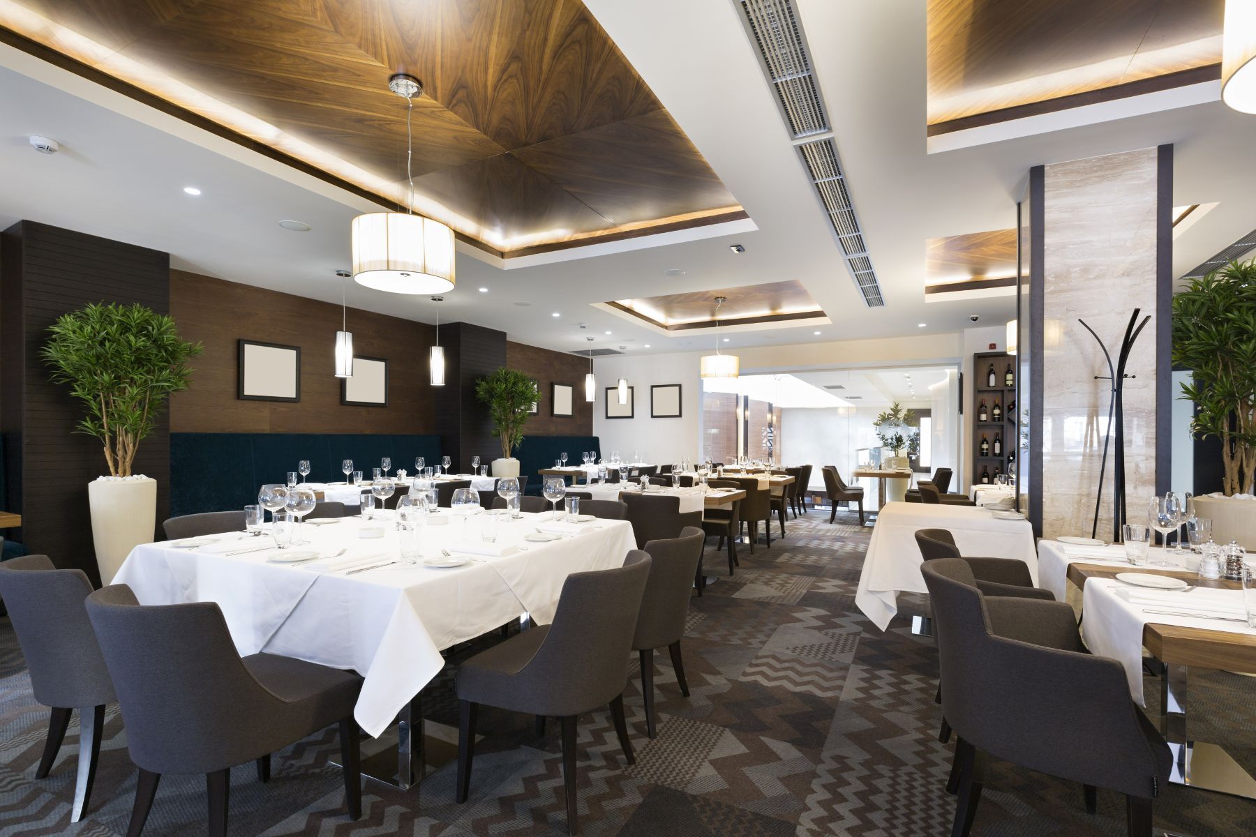 A restaurant with tables and chairs and a ceiling light.