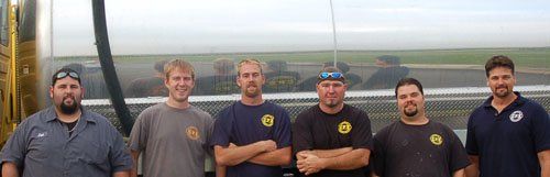 A group of men standing next to each other with their arms crossed.
