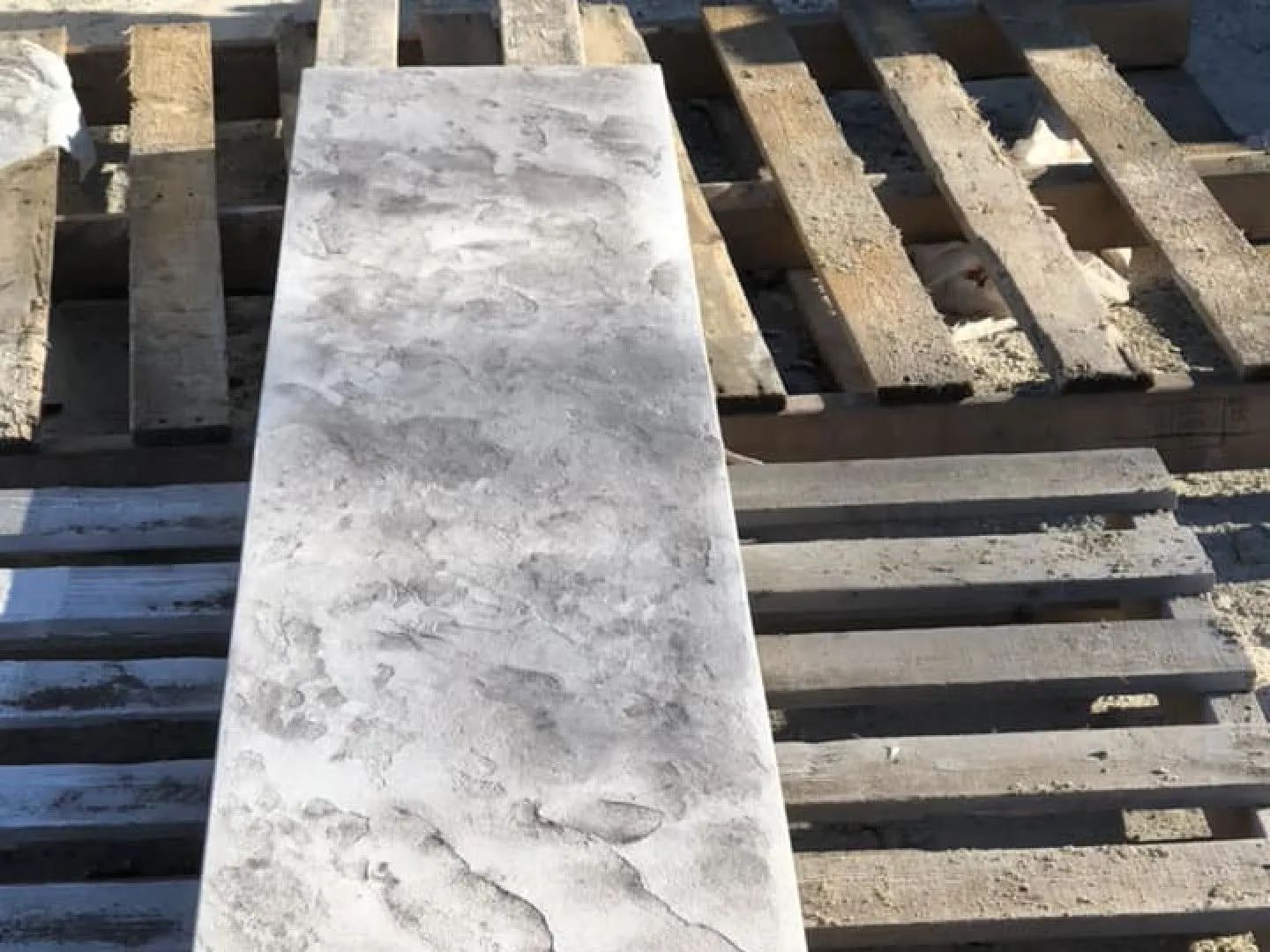 Gray rectangular concrete slab on a wooden pallet.