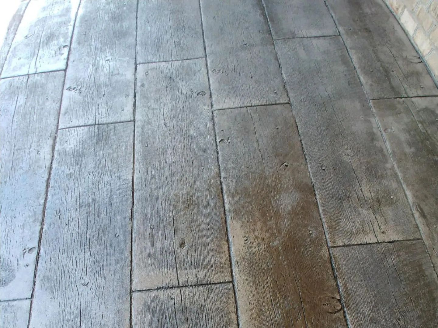 Gray, textured pavement made to look like wooden planks.