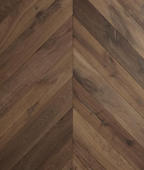 A close up of a wooden floor with a chevron pattern.