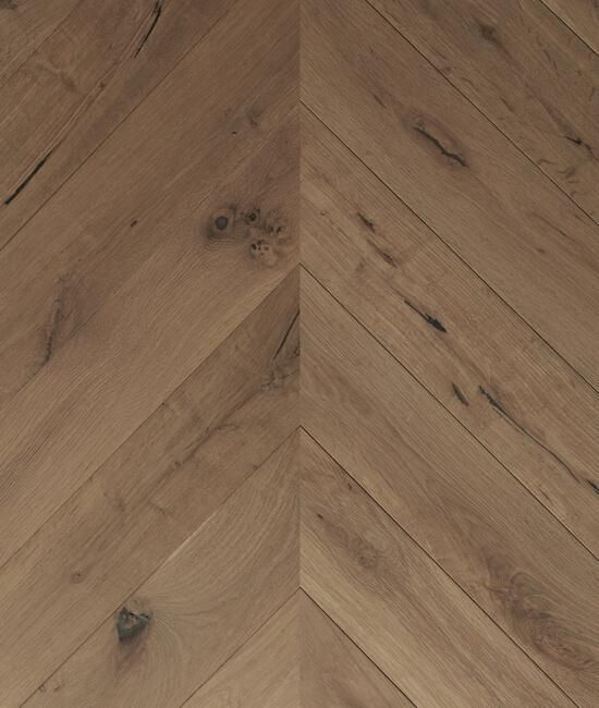 A close up of a wooden floor with a chevron pattern.