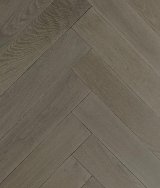 A close up of a wooden floor with a herringbone pattern.