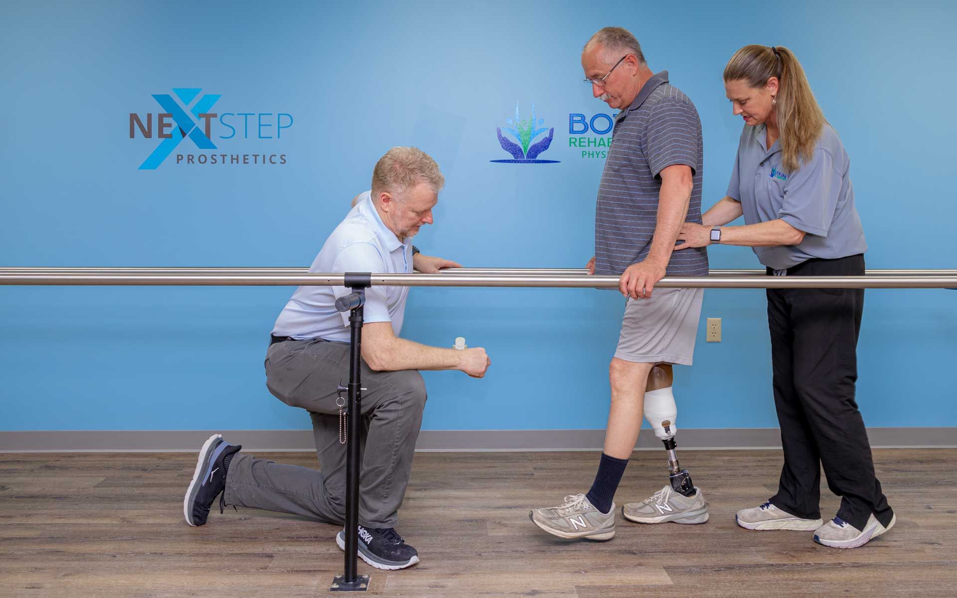 A man with a prosthetic leg is being helped by two people.