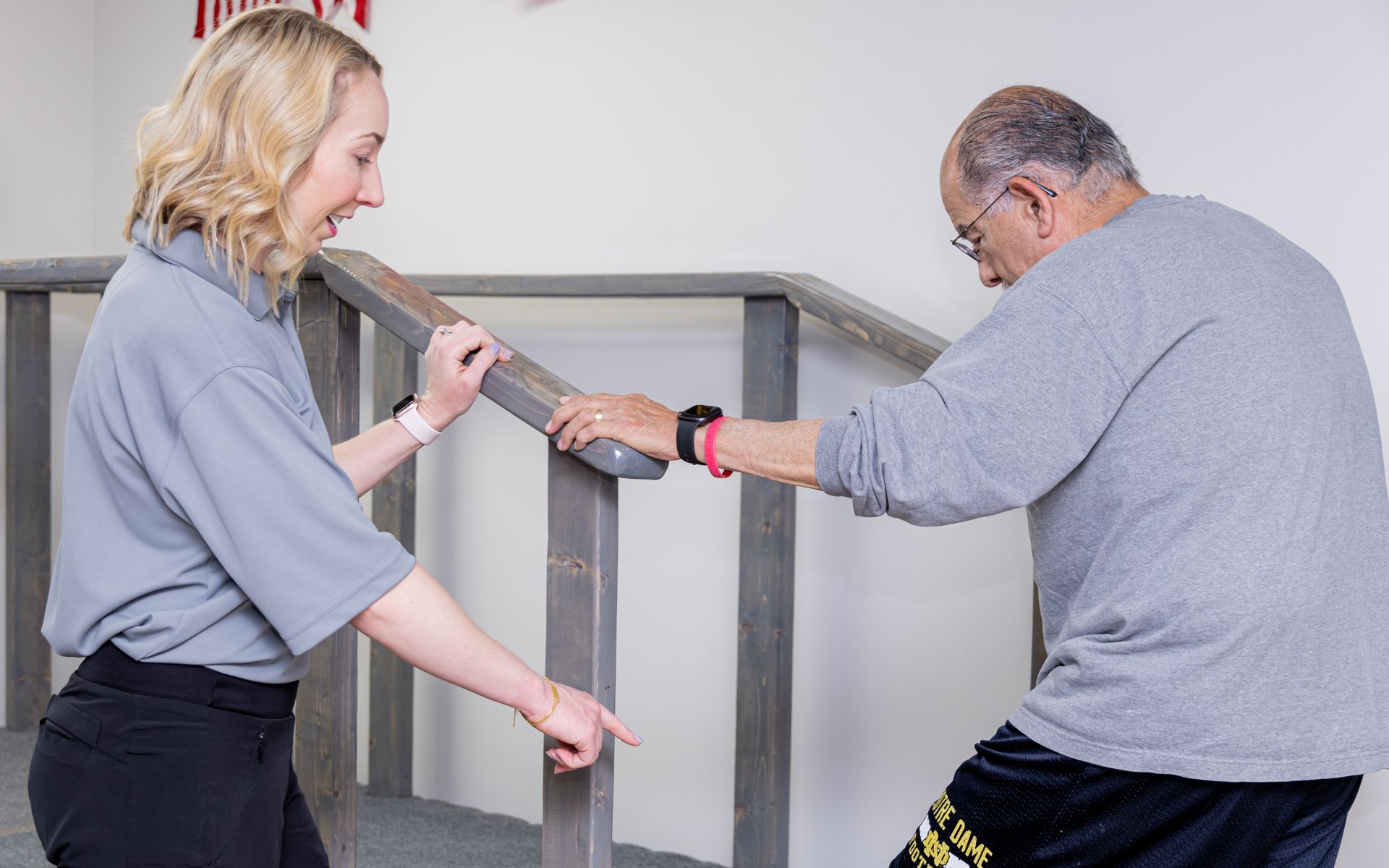 A woman is helping a man climb stairs
