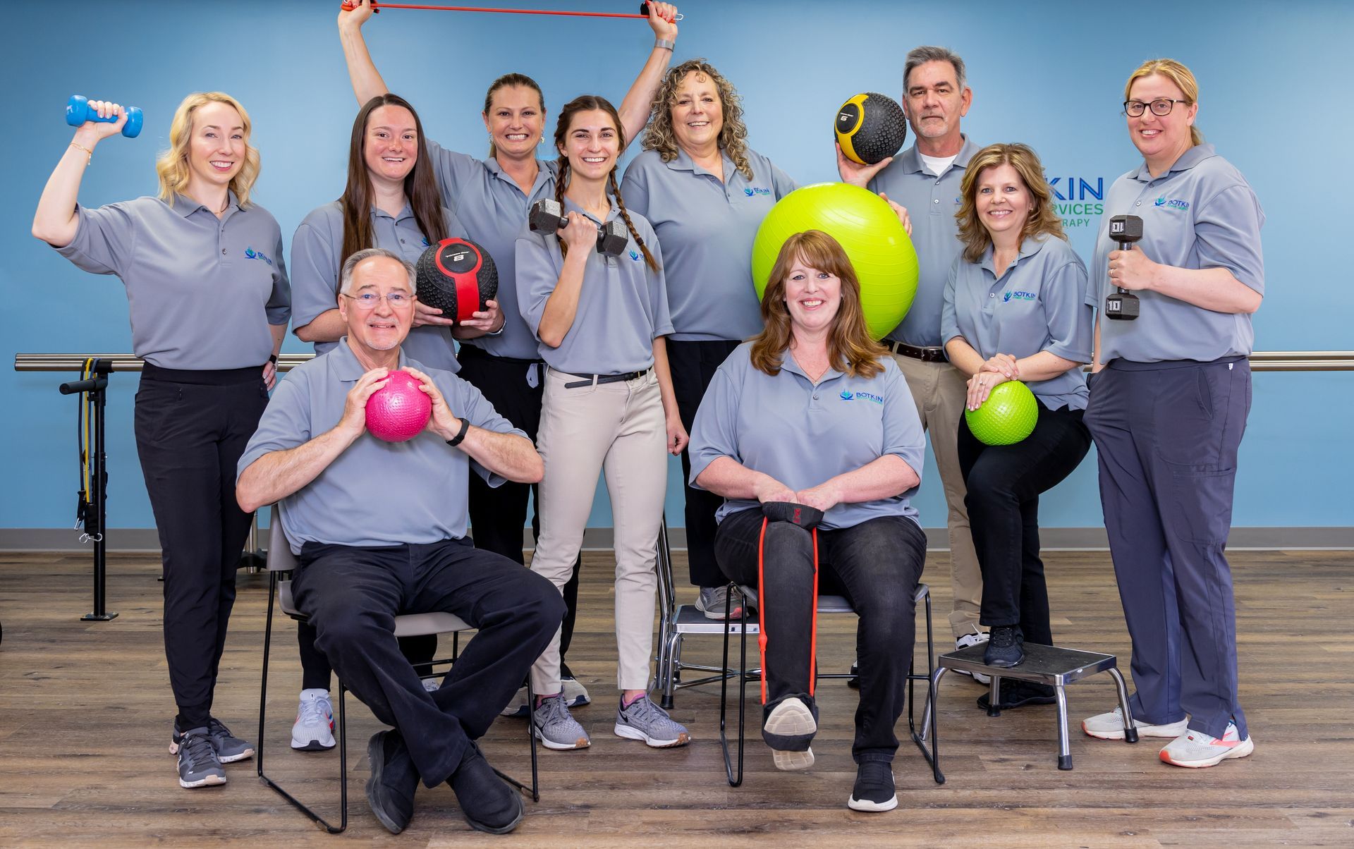 A group of people are posing for a picture in a gym with exercise equipment