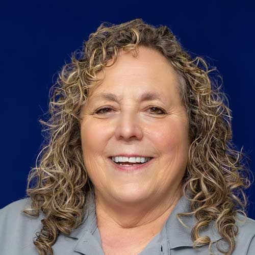 A woman with curly hair is smiling for the camera.