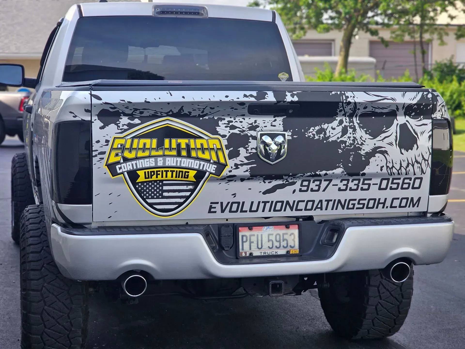 Silver Ram truck with Evolution Coatings logo, phone number, and website on the tailgate.