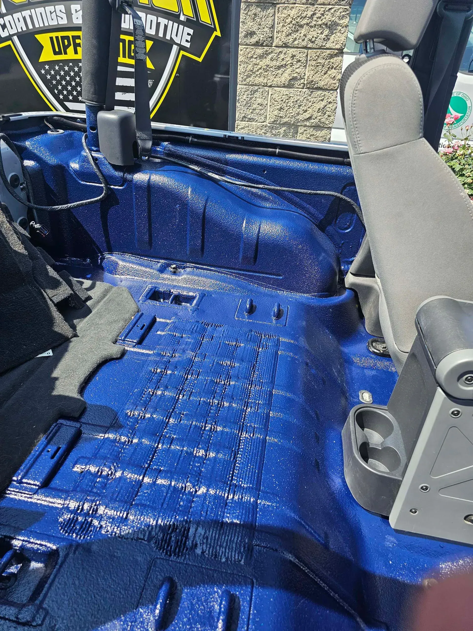 Blue painted interior of a vehicle, seats partially visible.