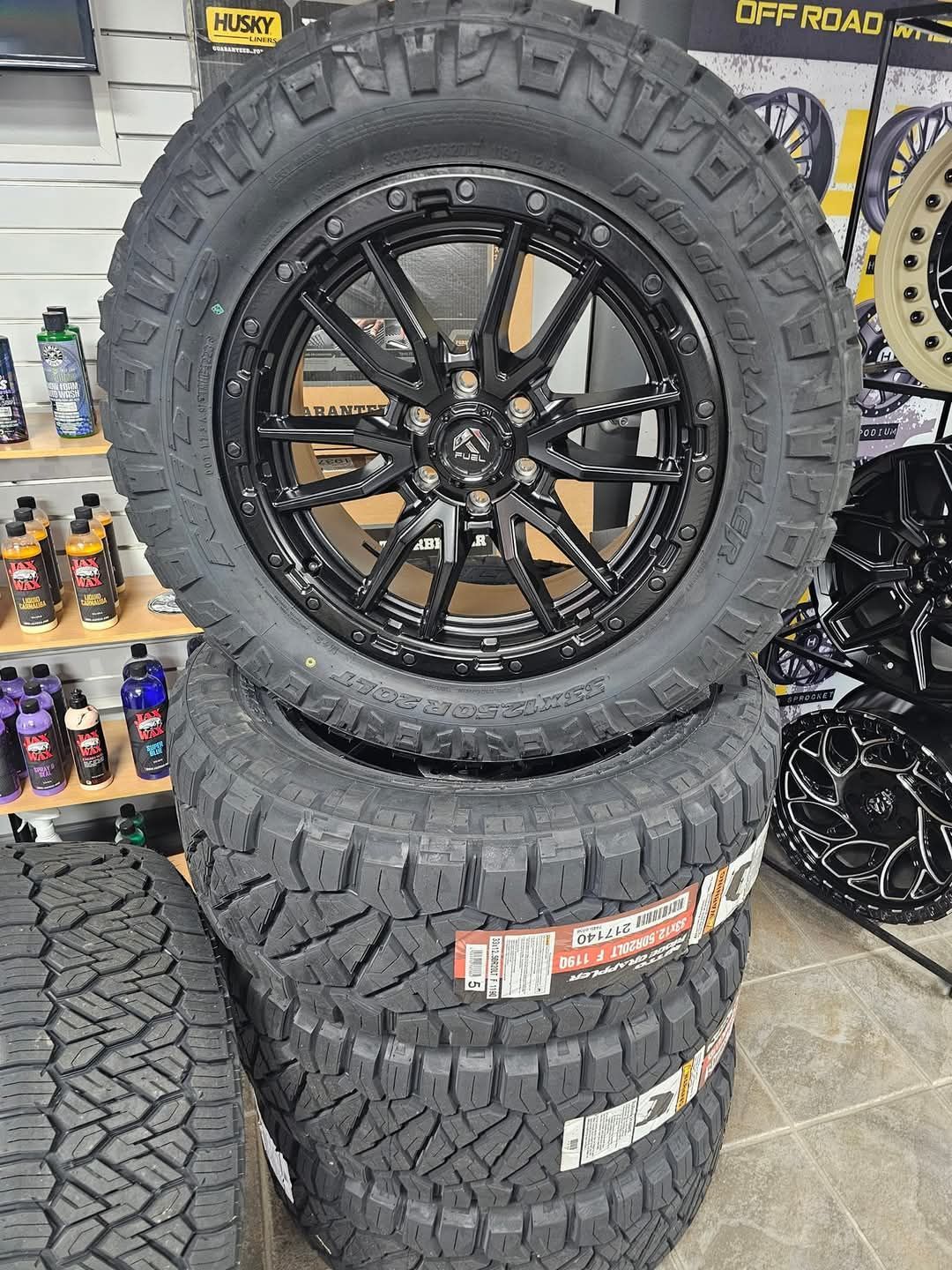 Black tire and rim set stacked on top of each other.