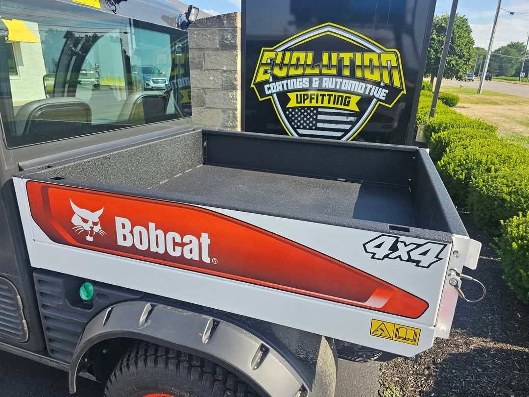 Bobcat 4x4 truck bed with Evolution logo and orange/white Bobcat logo. Outdoors.