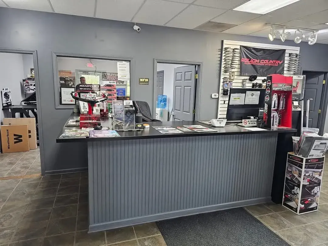 A retail store counter with products on display; gray facade; dark interior.