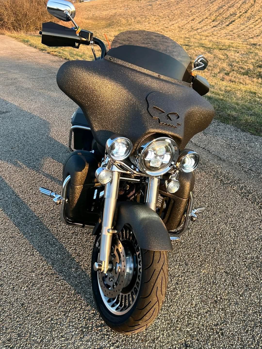 Black motorcycle with a textured fairing on a paved road.