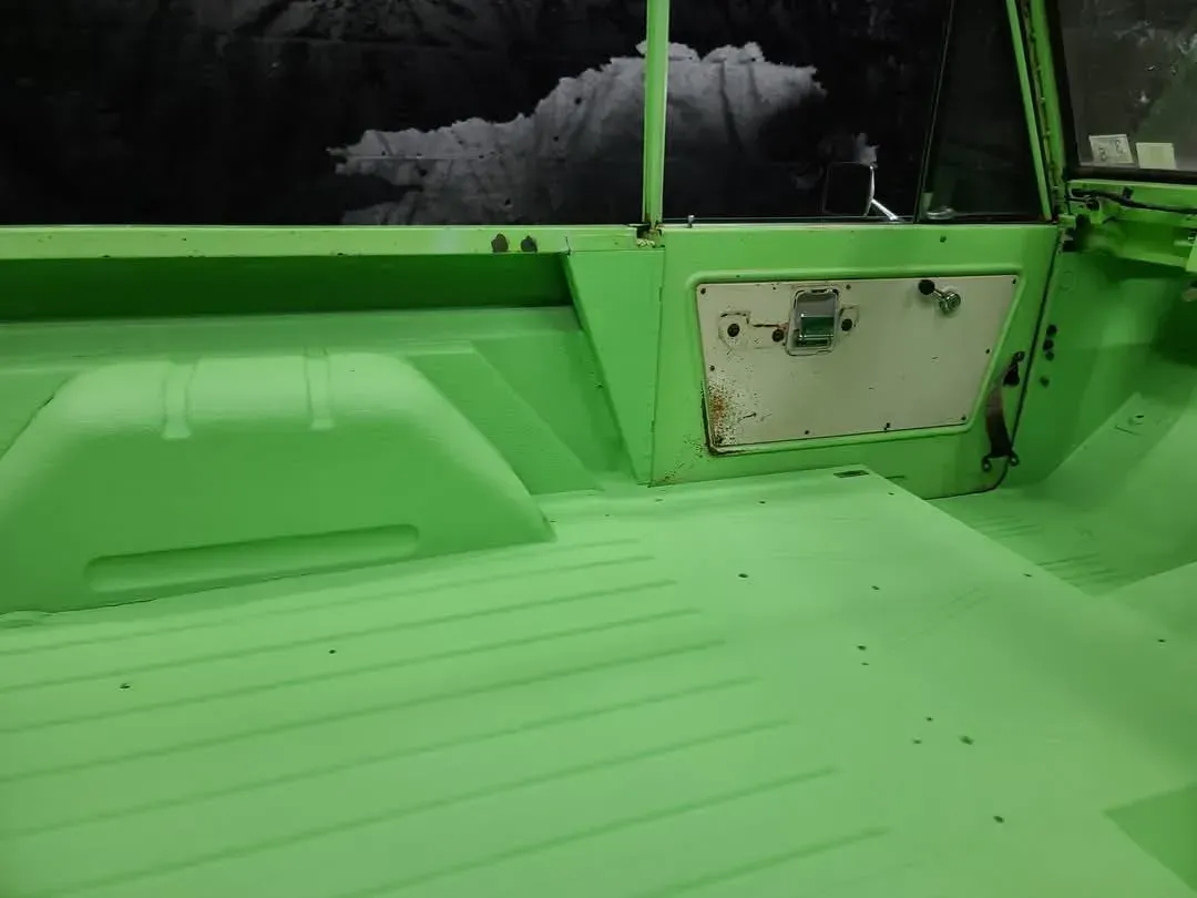Bright green interior of a vehicle, with a storage compartment visible on the side wall.