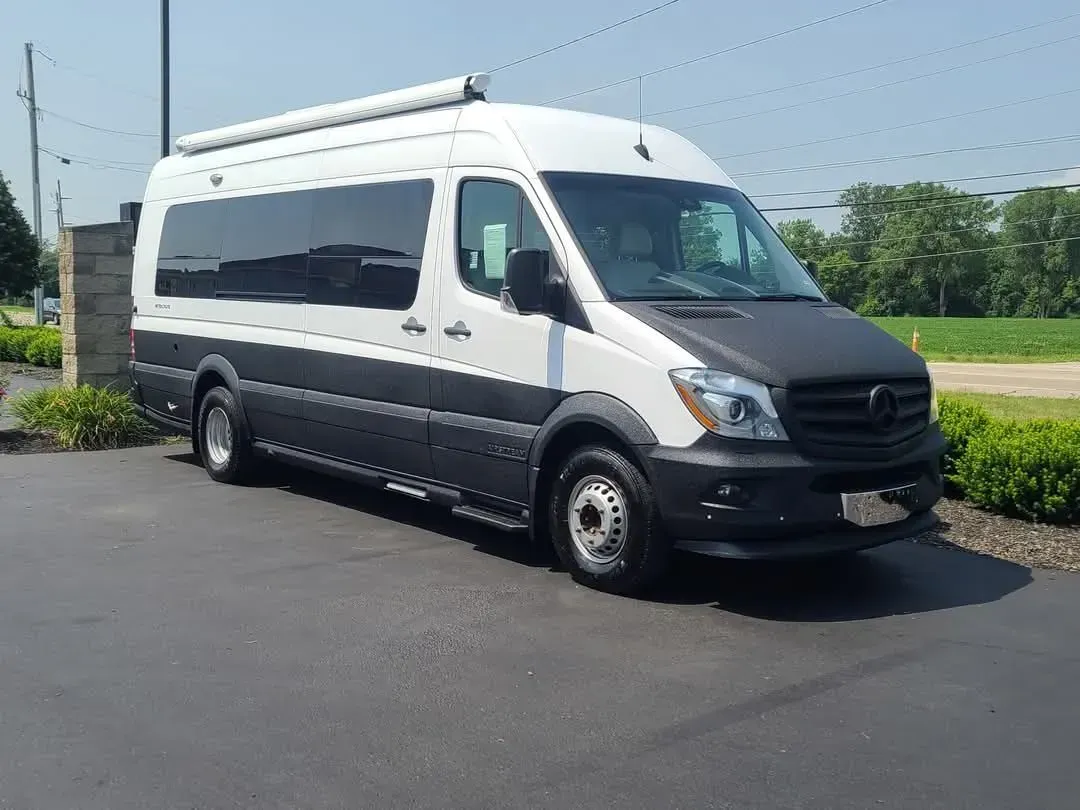 White and black camper van parked on asphalt. Daytime, exterior shot.