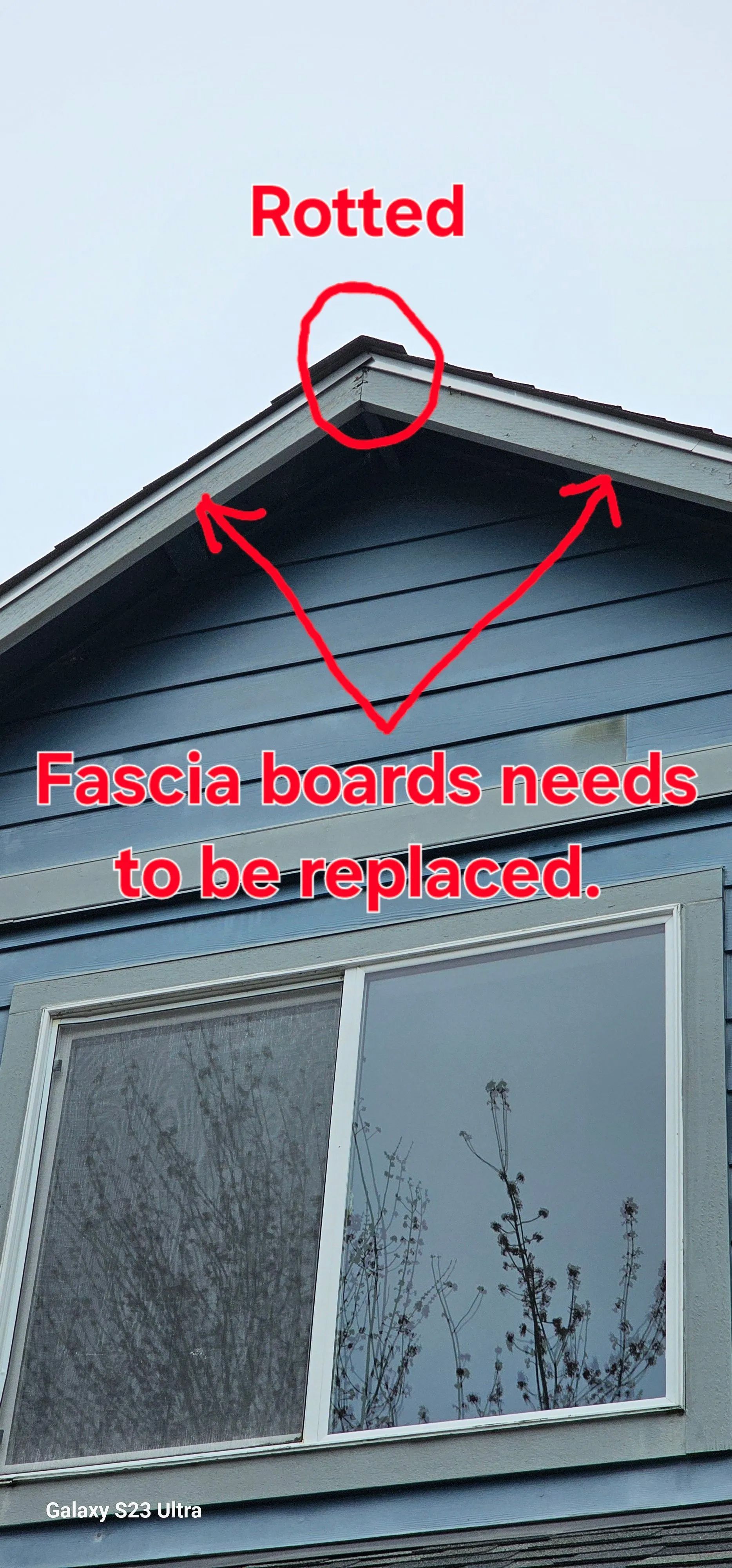 House roof gable with red annotations showing rotted trim and fascia boards needing replacement